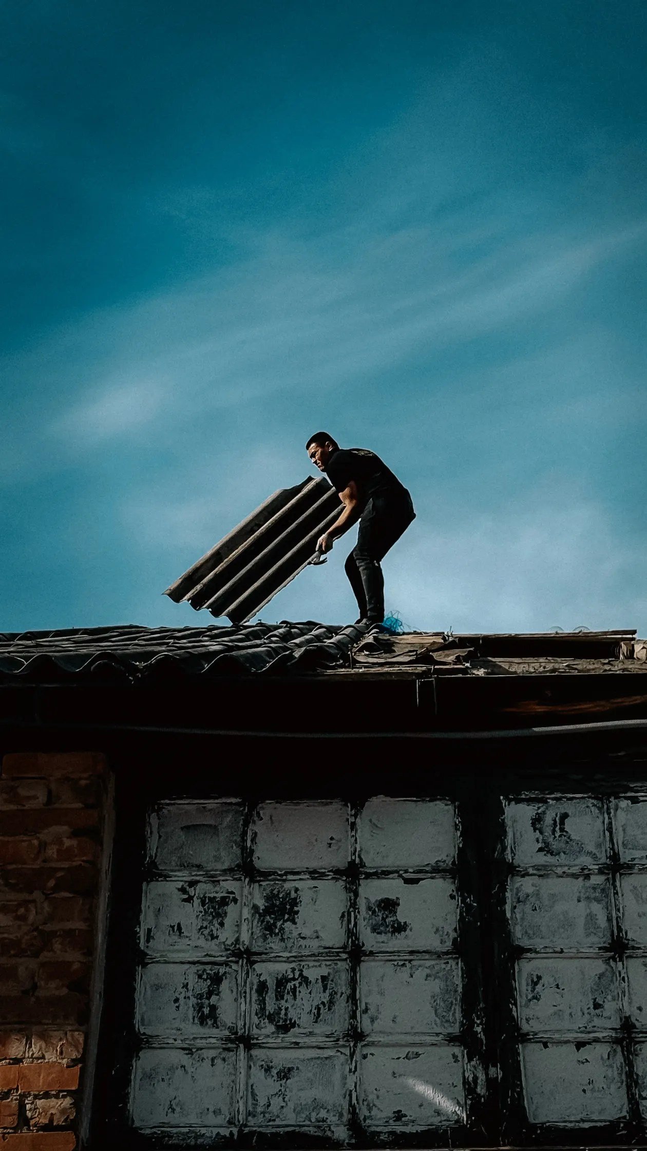 Roof repair Texas – roofer repairing shingles on a Texas home